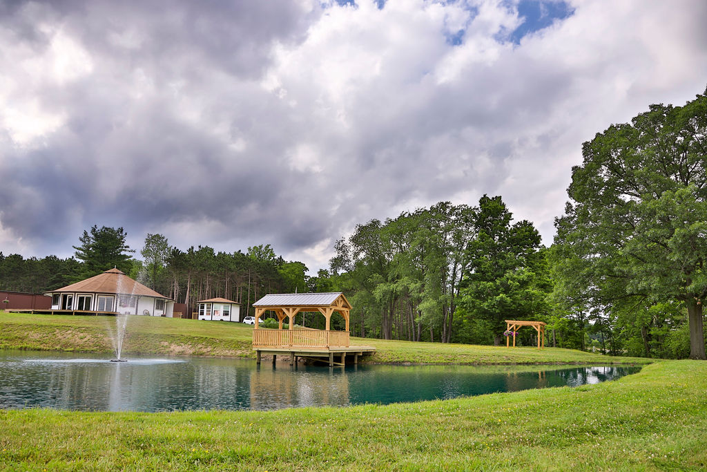 View of Rock Stream Retreat's pond, gazebo, pergola, cottage and bridal suite.